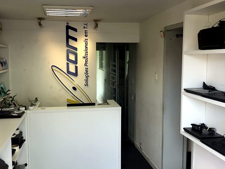 Recepção da MAY COM com o logo da empresa na parede